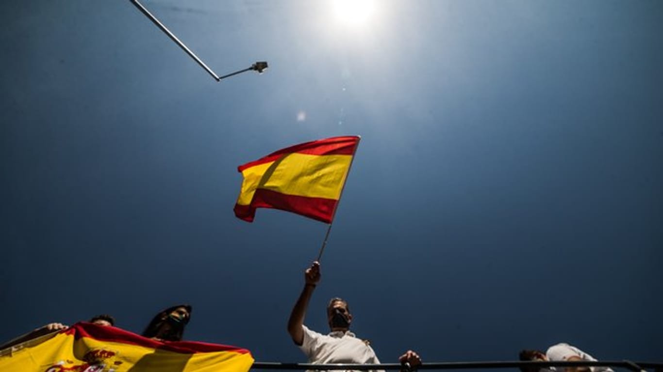Javier Ortega Smith, Generalsekretär der rechtspopulistischen Vox-Partei, schwenkt während einer Protest-Rallye eine spanische Flagge.
