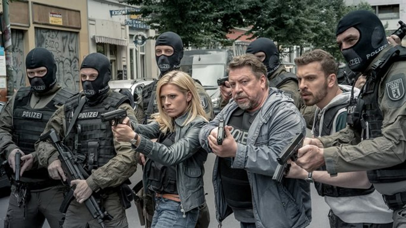 Lola Karras (Nele Kiper), Fredo Schulz (Armin Rohde) und Milan Filipovic (Edin Hasanovic) stehen mit gezogenen Waffen zwischen SEK-Beamten (l-r).