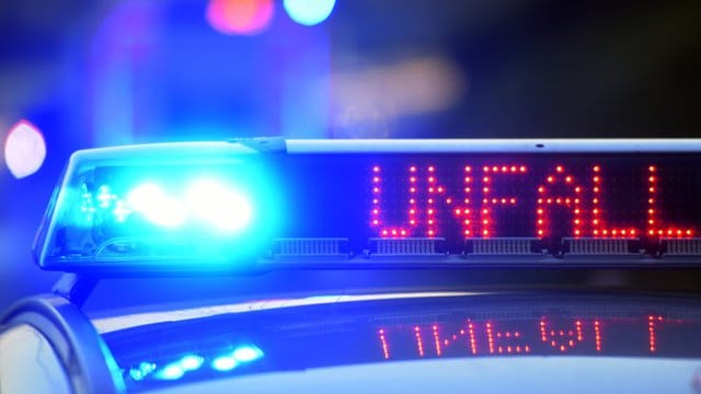 Auf einem Polizeifahrzeug warnt eine Leuchtschrift vor einer Unfallstelle.