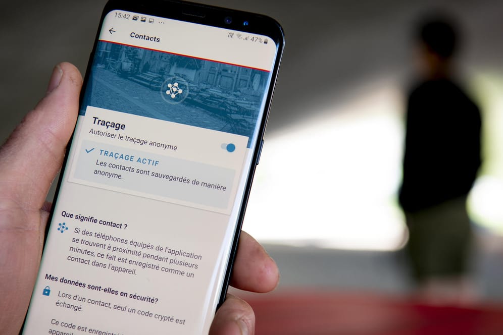 Ein Mann benutzt die Tracing-App SwissCovid auf seinem Smartphone: Eine ähnliche App zur Kontaktnachverfolgung soll es auch in Deutschland geben.