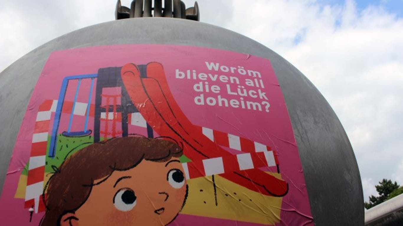 Auf einer Brunnenschale am Kölner Ebertplatz steht "Woröm blieven all die Lück doheim?": Das Projekt soll Kindern in einacher Sprache die Corona-Pandemie erklären.