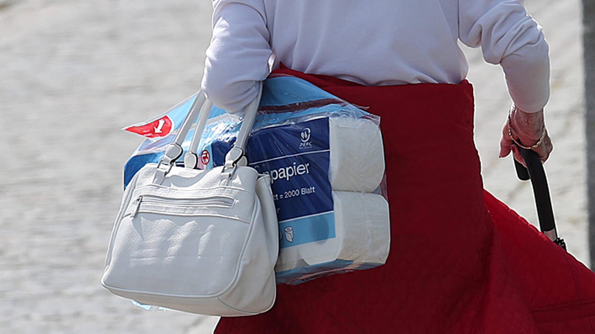 Seniorin mit einem Paket Toilettenpapier: Um die Ware gab es zu Beginn der Pandemie einen regelrechten Hype.