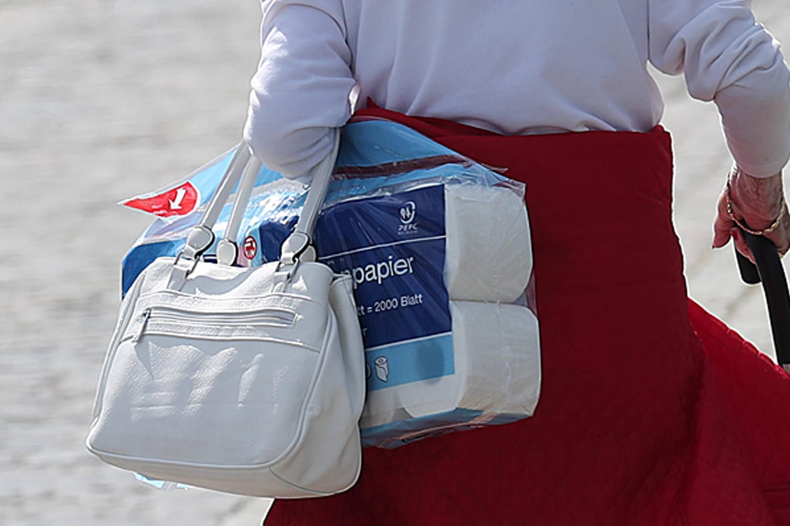 Seniorin mit einem Paket Toilettenpapier: Um die Ware gab es zu Beginn der Pandemie einen regelrechten Hype.