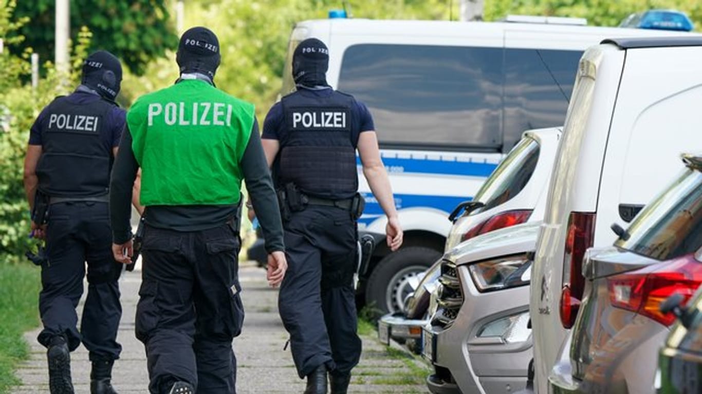 Bundespolizisten laufen vor einem Haus in Leipzig Grünau entlang.