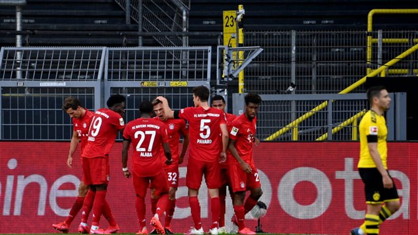 Die Bayern-Spieler feiern in Dortmund den Matchwinner Joshua Kimmich (M).
