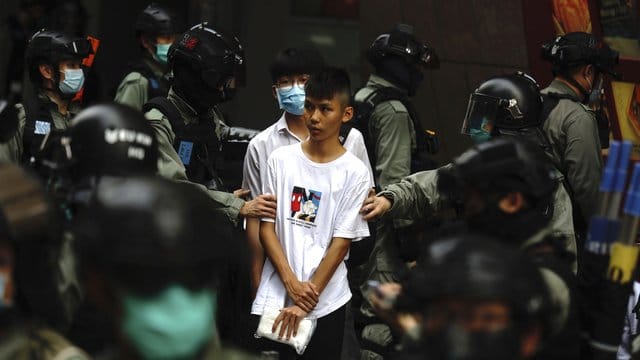 Bereitschaftspolizisten halten im Zentrum von Hongkong zwei junge Demonstranten fest. Bereitschaftspolizisten halten im Zentrum von Hongkong zwei junge Demonstranten fest.