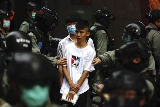 Bereitschaftspolizisten halten im Zentrum von Hongkong zwei junge Demonstranten fest.