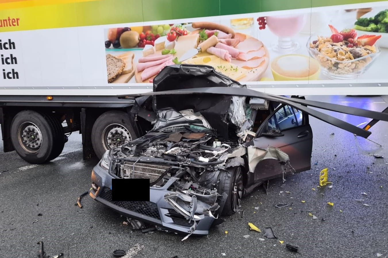 Ein Mercedes ist unter einen Sattelauflieger gerutscht: Der Pkw-Fahrer erlitt leichte Verletzungen.