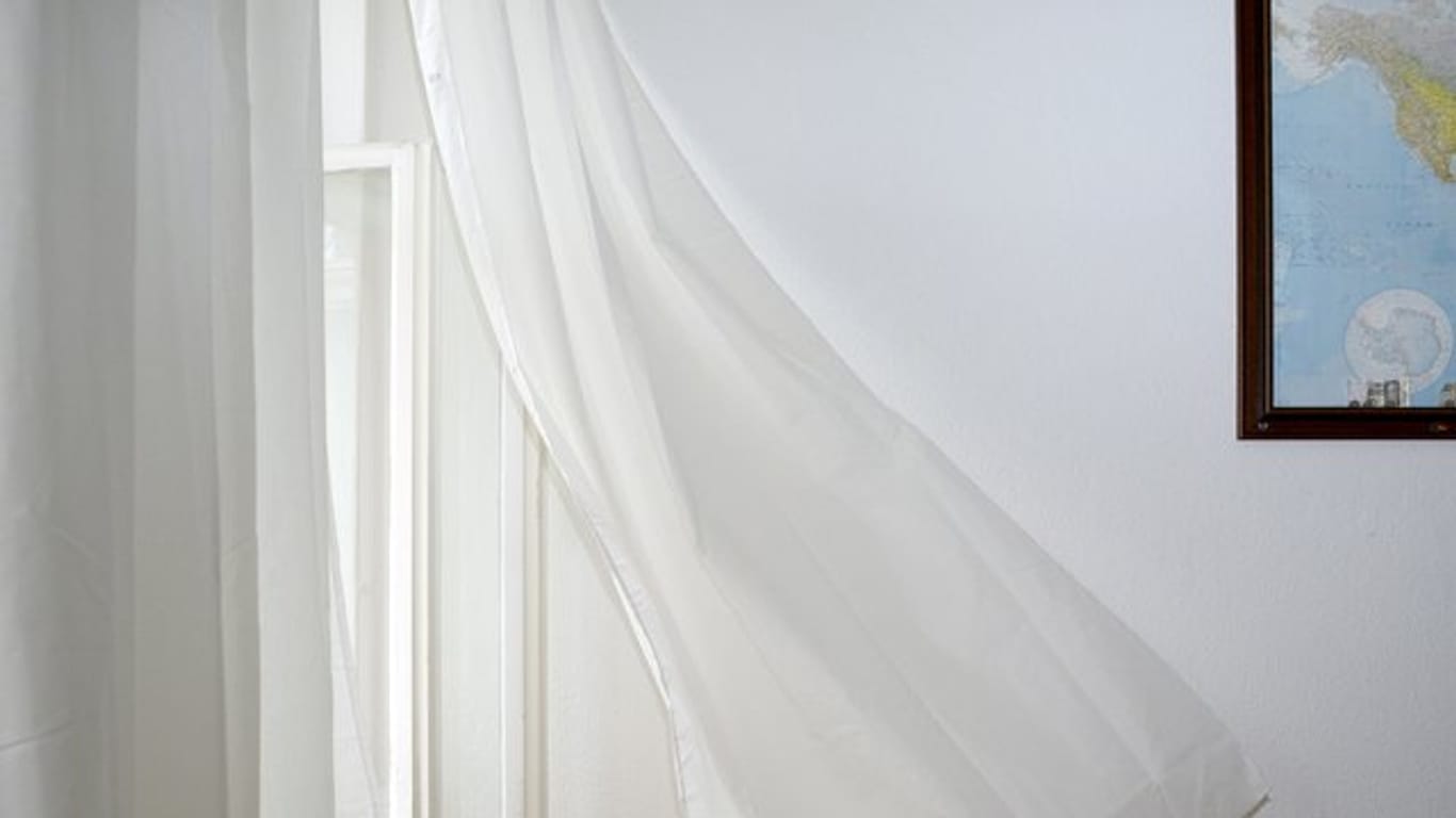 Ein Vorhang weht im Durchzug: Gelüftet wird während heißen Perioden am besten nachts.