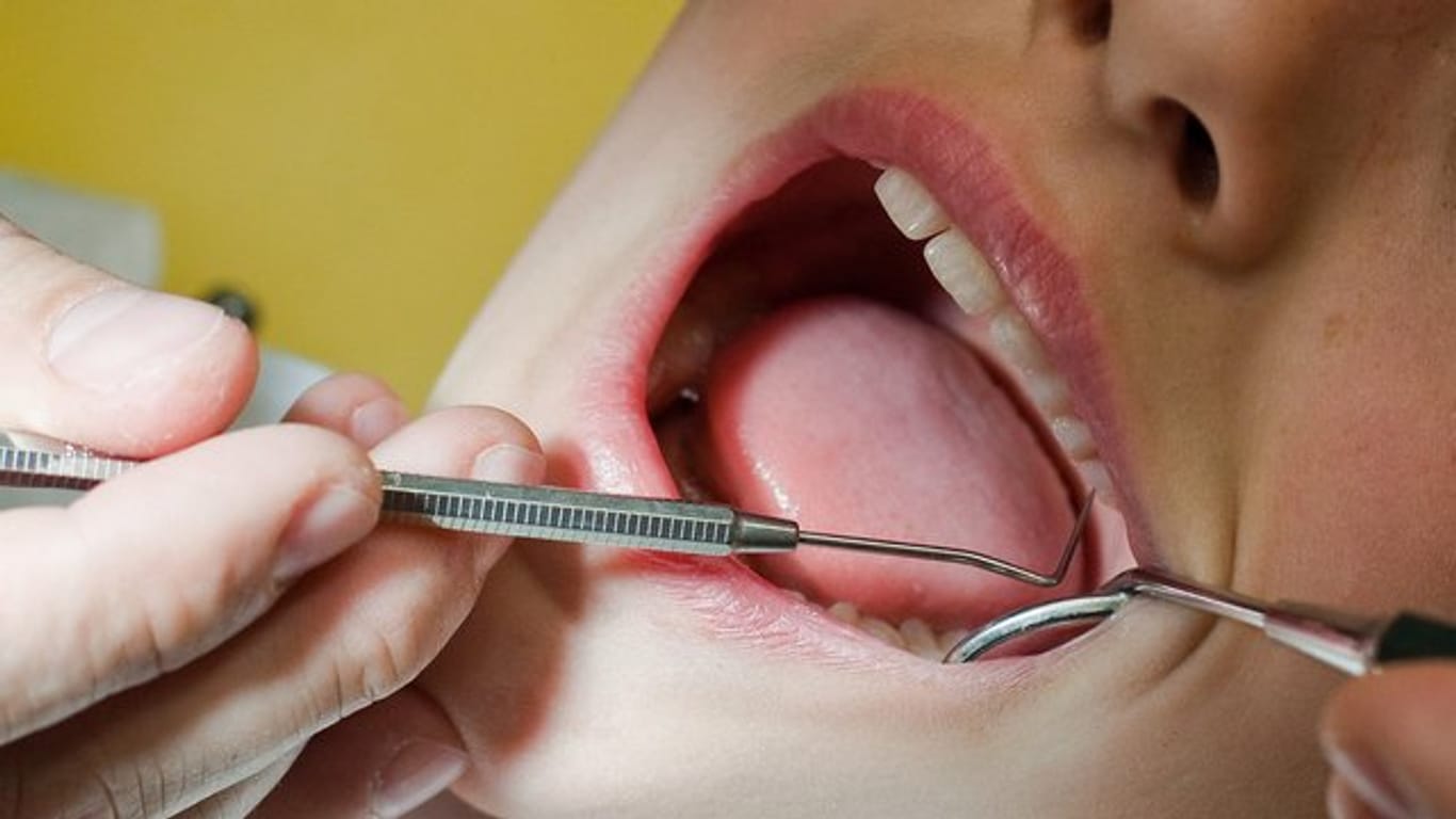 In einer Zahnarztpraxis werden die Zähne eines Neunjährigen untersucht.