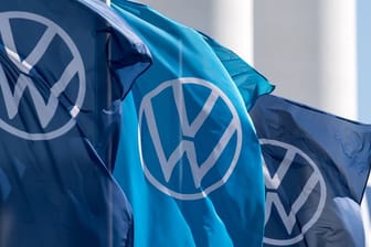 Fahnen mit dem VW-Logo wehen vor einem Fahrzeugwerk