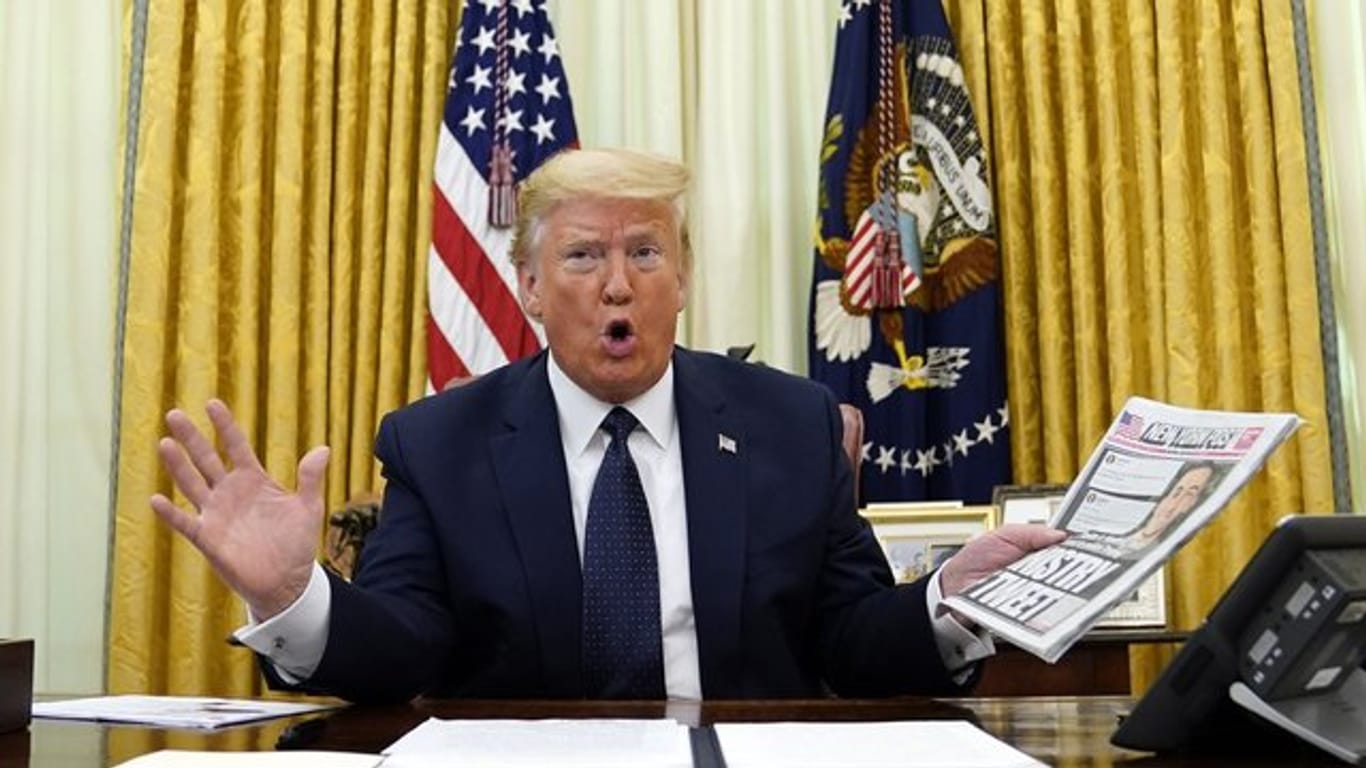 US-Präsident Donald Trump zeigt im Oval Office das Titelblatt der Zeitung "New York Post" mit dem Titel "Ministry of Tweet" ("Ministerium des Tweets").