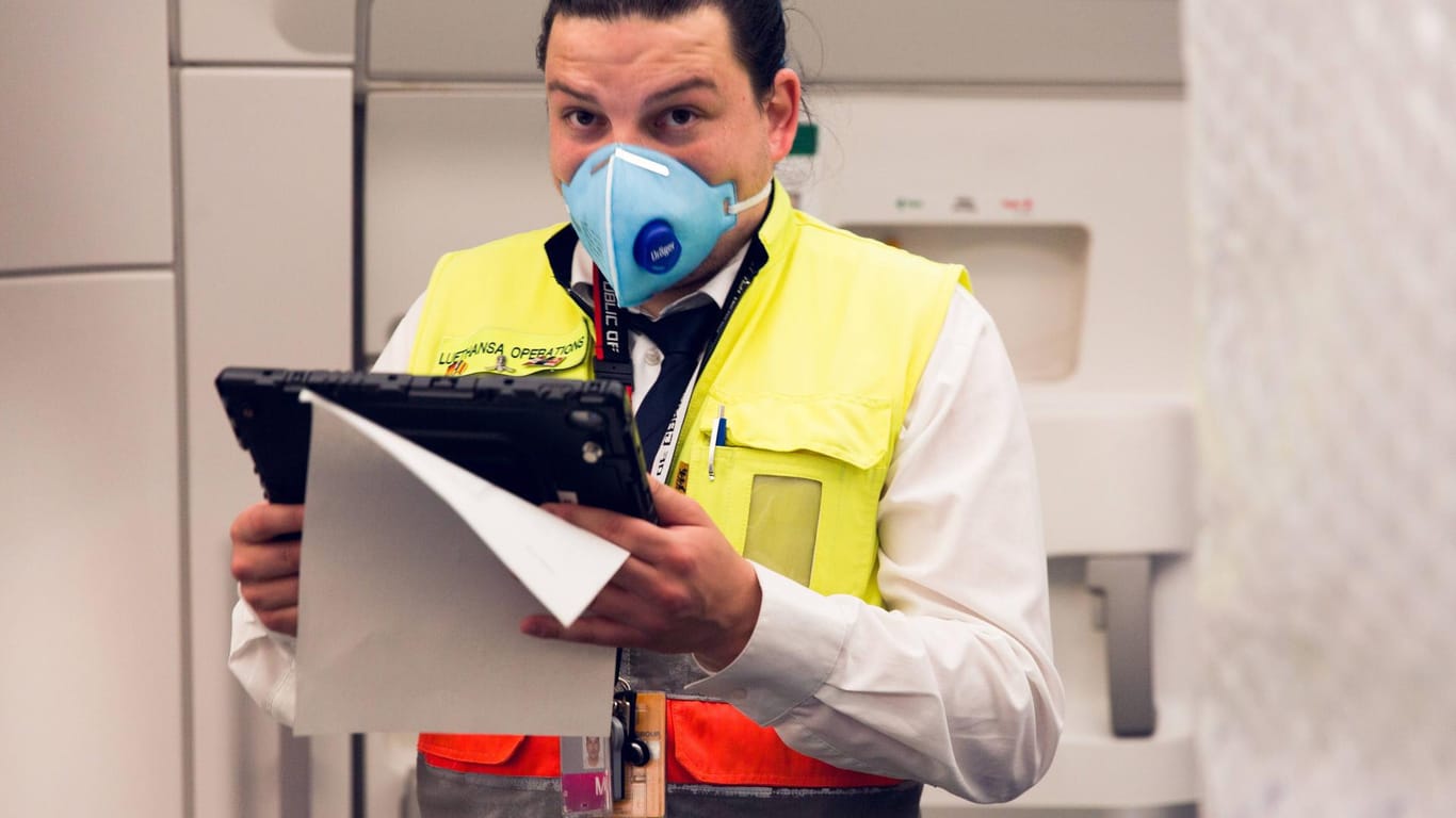 Lufthansa-Mitarbeiter mit Atemmaske: Wie groß ist das Infektionsrisiko in der Flugzeugkabine wirklich?