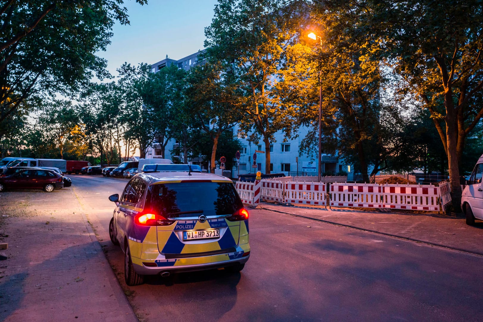 Ein Polizeifahrzeug steht am Rande einer Hochhaussiedlung in Dietzenbach: Etwa 50 Männer haben im hessischen Dietzenbach einen Brand gelegt und anschließend die Rettungskräfte angegriffen.