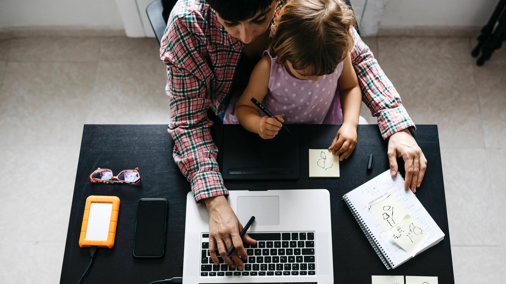 Eine Frau mit Kind arbeitet im Homeoffice: In der Corona-Krise müssen Frauen häufig gleichzeitig arbeiten und die Kinder betreuen.