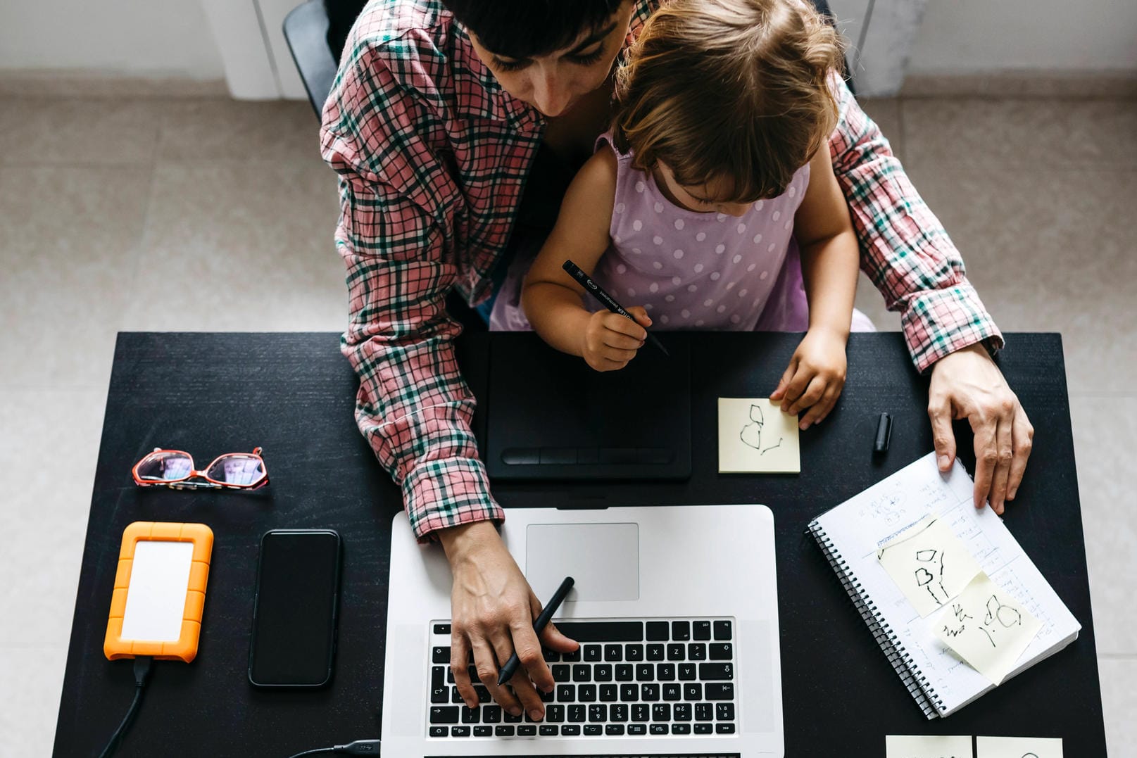 Eine Frau mit Kind arbeitet im Homeoffice: In der Corona-Krise müssen Frauen häufig gleichzeitig arbeiten und die Kinder betreuen.