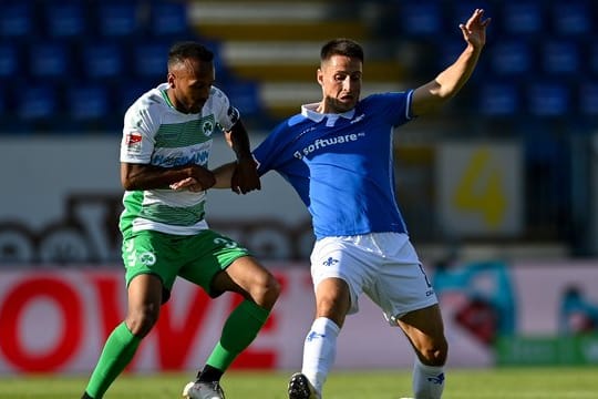 Der Fürther Julian Green (l) hält Fabian Schnellhardt im Zweikampf fest.