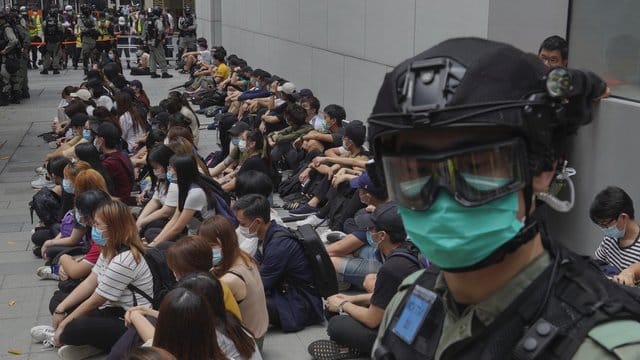 Von Bereitschaftspolizisten festgehaltene regierungskritische Demonstranten im Zentrum von Hongkong. Von Bereitschaftspolizisten festgehaltene regierungskritische Demonstranten im Zentrum von Hongkong.