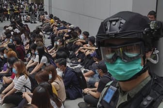 Von Bereitschaftspolizisten festgehaltene regierungskritische Demonstranten im Zentrum von Hongkong.