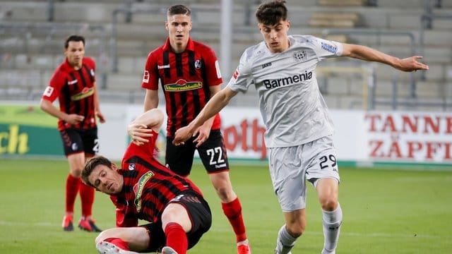 Kai Havertz (r) setzt sich gegen den Freiburger Dominique Heintz durch.