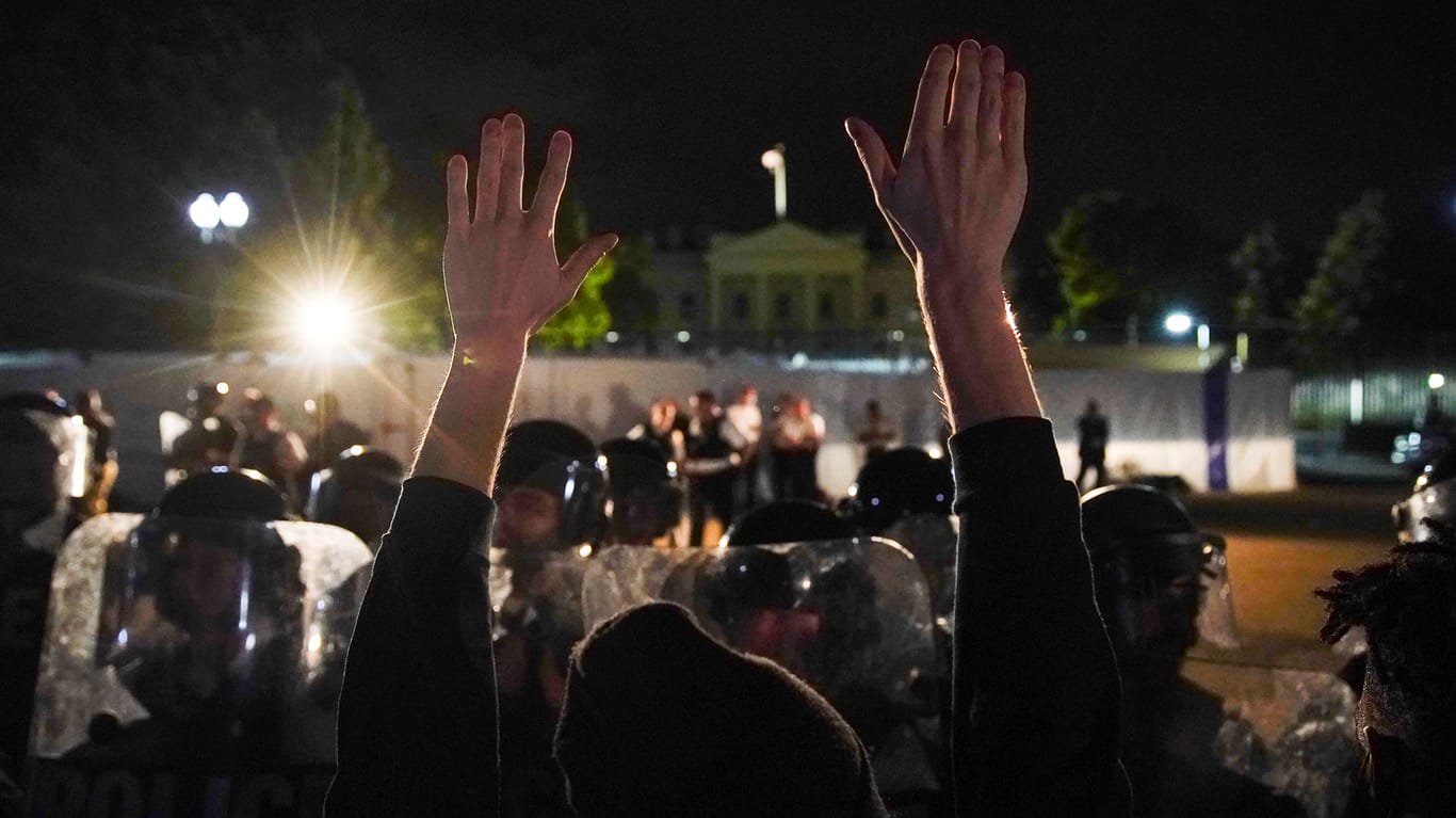 Ein Demonstrant reckt die Hände in die Höhe: In Minneapolis gehen die Proteste trotz Ausgangssperre weiter.