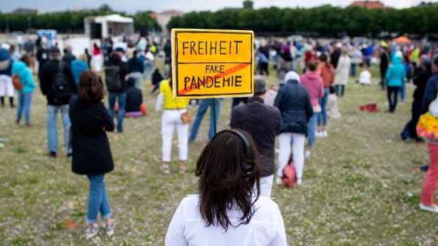 "Freiheit/Fake-Pandemie": Eine Teilnehmerin einer Demonstration mit einem Protestschild in München. "Freiheit/Fake-Pandemie": Eine Teilnehmerin einer Demonstration mit einem Protestschild in München.