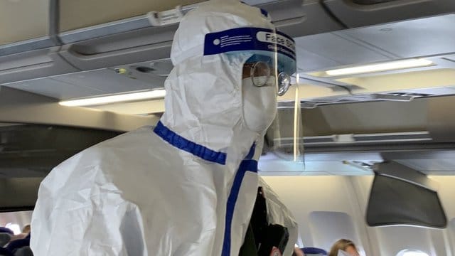 Ein Beamter der chinesischen Gesundheitsbehörde begleitet den Sonderflug, um die Körpertemperatur von Passagieren zu messen und nach Krankheitssymptomen zu fragen. Ein Beamter der chinesischen Gesundheitsbehörde begleitet den Sonderflug, um die Körpertemperatur von Passagieren zu messen und nach Krankheitssymptomen zu fragen.