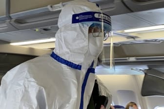 Ein Beamter der chinesischen Gesundheitsbehörde begleitet den Sonderflug, um die Körpertemperatur von Passagieren zu messen und nach Krankheitssymptomen zu fragen.