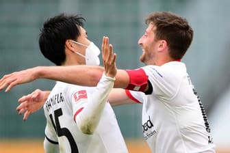 Die Frankfurter Daichi Kamada (l) und David Abraham feiern nach Spielende den Sieg in Wolfsburg.