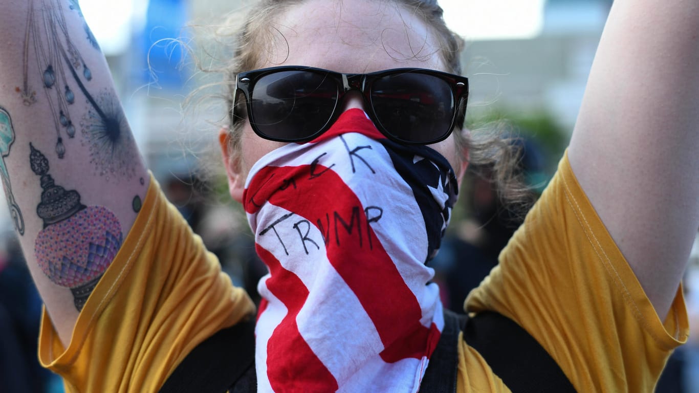 "Fu** Trump" heißt es auf dem Tuch einer jungen Frau, die gegen die Politik des US-Präsidenten demonstriert.