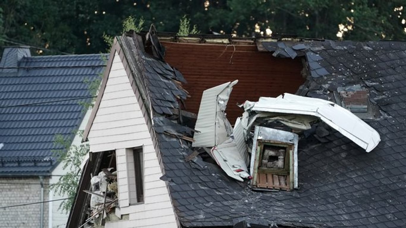 Wrackteile des Kleinflugzeuges ragen aus dem Dach des Wohnhauses.