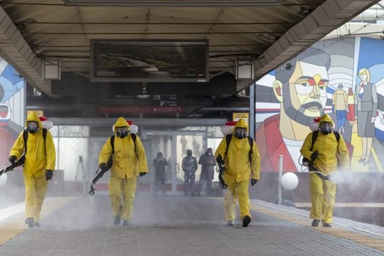 Städtische Angestellte desinfizieren einen Bahnhof in Moskau.