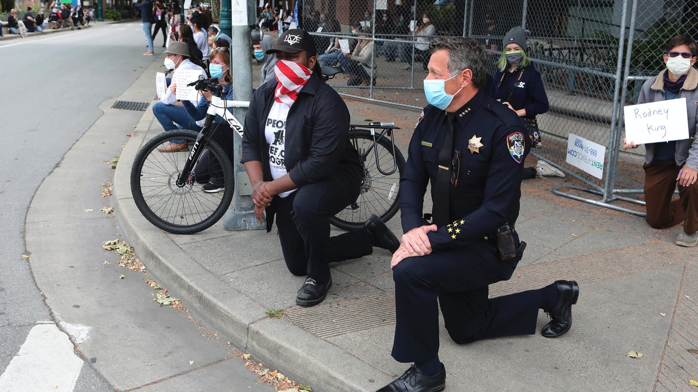Der Polizeichef von Santa Cruz, Andy Mills, kniet auf der Straße: In einigen Städten beteiligte sich die Polizei an friedlichen Protesten.