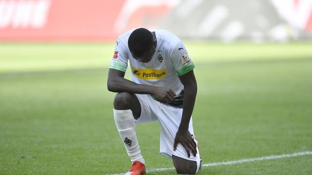 Mönchengladbachs Marcus Thuram kniet nach seinem ersten Treffer der Partie auf dem Rasen.