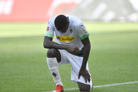 Mönchengladbachs Marcus Thuram kniet nach seinem ersten Treffer der Partie auf dem Rasen.
