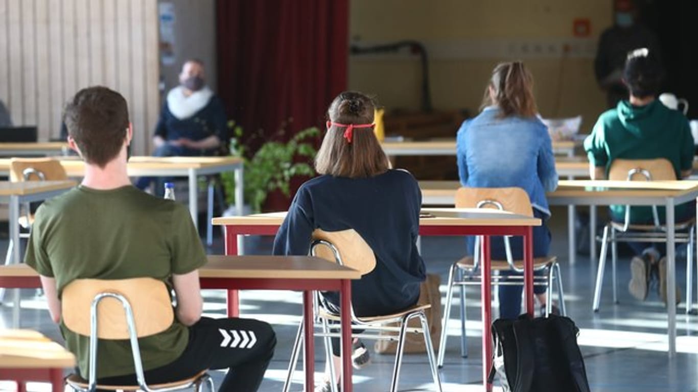 Schüler mit Mundschutz sitzen an ihren Tischen (Symbolbild): In Thüringen kehren nun alle Kinder und Jugendliche wieder zurück.