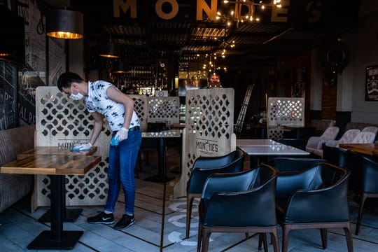 Ein Mitarbeiter reinigt die Tische eines Restaurants in Istanbul vor der Wiedereröffnung.