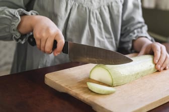 Ein Mädchen schneidet eine Zucchini: In Myanmar ist eine Achtjährige durch Koch-Videos überregional bekannt geworden. (Symbolbild)