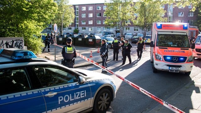 Einsatzkräfte von Polizei und Rettungsdienst stehen am Tatort Einsatzkräfte von Polizei und Rettungsdienst stehen am Tatort
