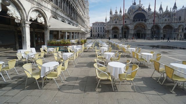 Leere Stühle und Tische vor einem Restaurant auf dem Markusplatz.