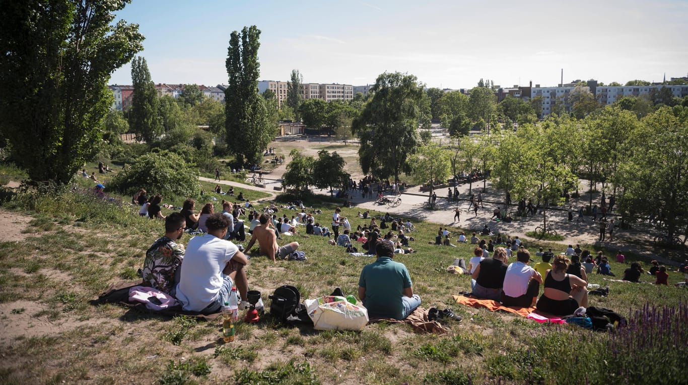 Menschen sitzen auf einer Wiese im Mauerpark in Berlin: Unter anderem dort wurden Polizisten von aggressiven Gruppen belästigt.