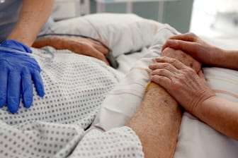 Krankenschwestern betreuen in einem Krankenhaus einen Patienten auf einer Intensivstation.