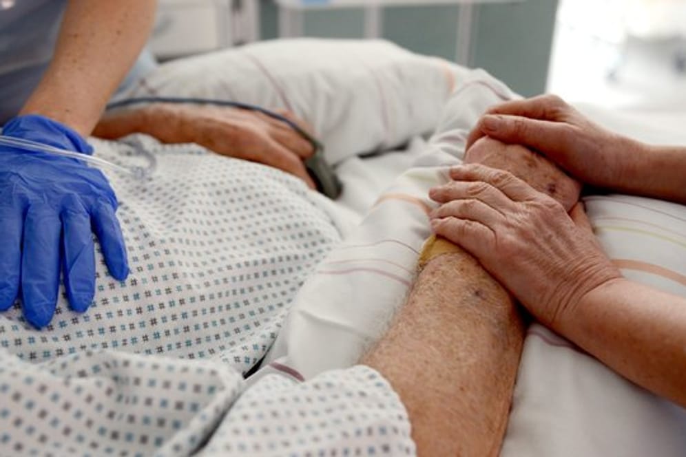 Krankenschwestern betreuen in einem Krankenhaus einen Patienten auf einer Intensivstation.