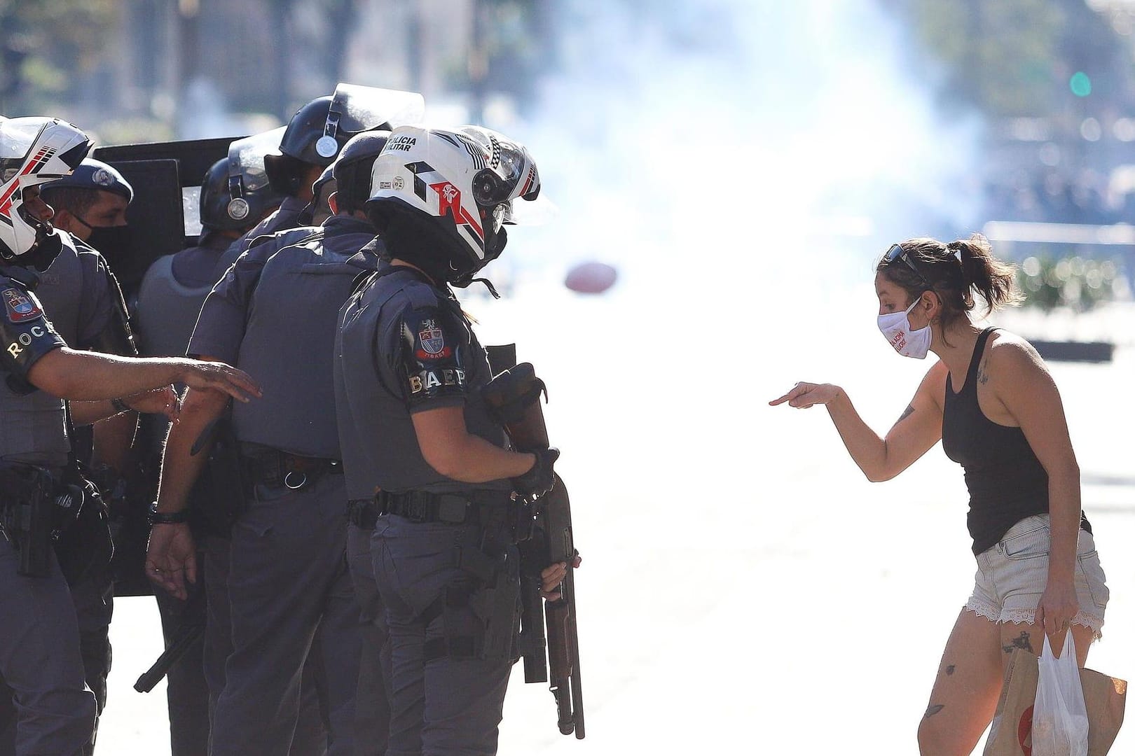 Eine Demonstratin in Brasilien steht der Polizei gegenüber. Sie demonstriert gegen die Corona-Politik des Präsidenten Jair Bolsonaro. Obwohl die Fallzahlen steigen, nimmt er die Gefahr nicht ernst.