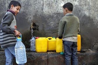 Zwei Jungen holen in Sanaa Wasser an einer Pumpe.