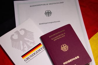 Einbürgerungsurkunde, Grundgesetz und Reisepass: Die Zahl der Einbürgerungen ist im vergangenen Jahr deutlich gestiegen.