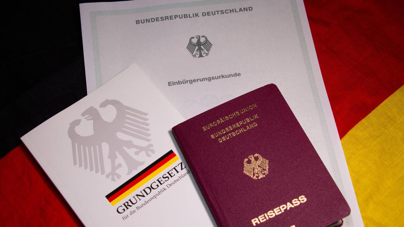 Einbürgerungsurkunde, Grundgesetz und Reisepass: Die Zahl der Einbürgerungen ist im vergangenen Jahr deutlich gestiegen.