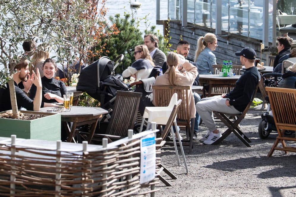 Menschen genießen die Frühlingssonne in einem Restaurant in Stockholm (Archivbild): Das skandinavische Land hatte während der Corona-Pandemie keinen Lockdown ausgerufen.