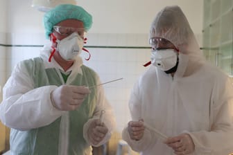 Zwei Mediziner mit Mundschutz, Schutzbrille und Schutzanzug: Wesentlich für den Schutz vor Ansteckung ist laut Forschern zudem das Abstandhalten.