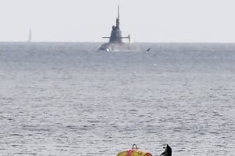 Ein Tümmler springt aus der Ostsee, im Hintergrund ein deutsches Uboot: Auch die USA, Großbritannien und Kanada stellen Marine-Kontingente für das "Baltops"-Manöver.